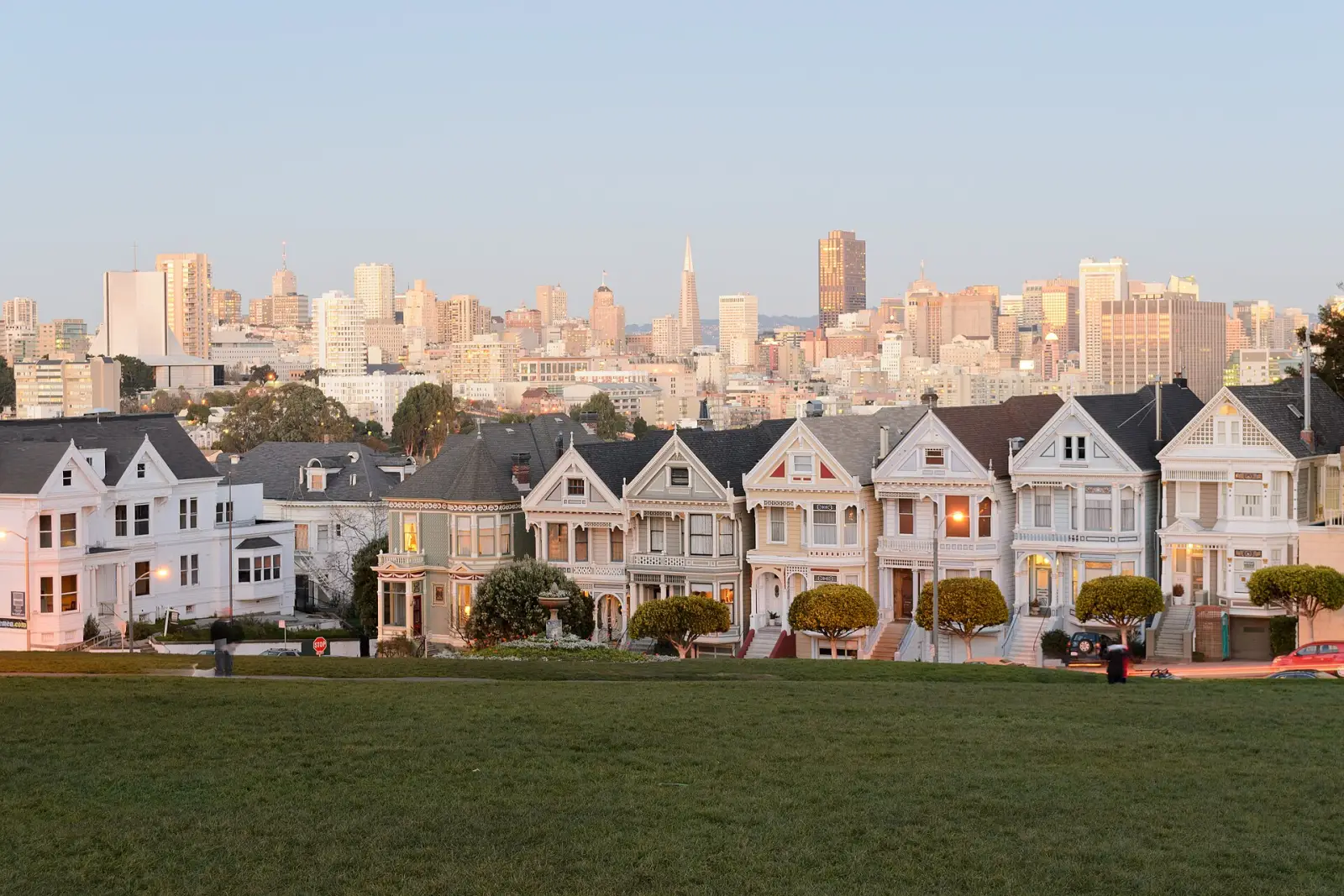 The Painted Ladies Victorian houses on Steiner Street, seen from Alamo Square park, with the San Francisco skyline behind